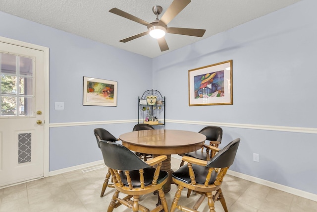 dining room featuring ceiling fan and a textured ceiling