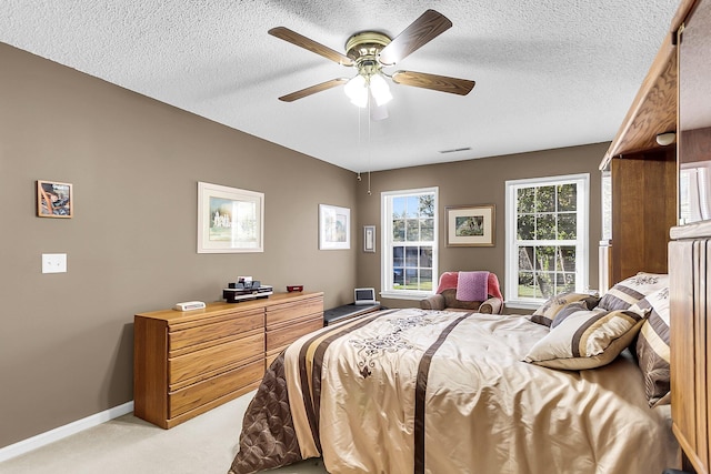 carpeted bedroom featuring a textured ceiling and ceiling fan