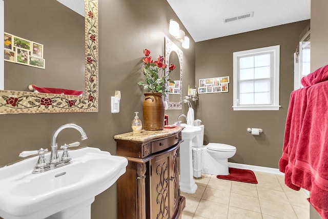 bathroom featuring tile patterned floors, toilet, sink, and a textured ceiling