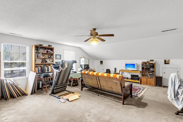 interior space featuring a textured ceiling, ceiling fan, lofted ceiling, and light carpet