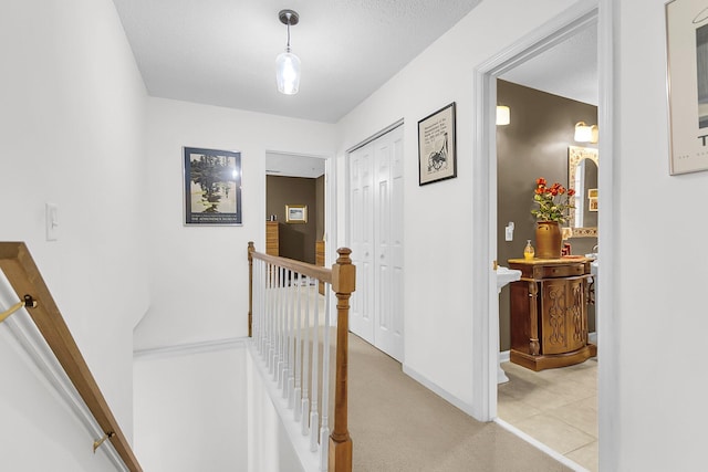 hall featuring a textured ceiling and light carpet