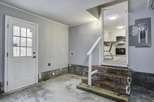 foyer with ornamental molding, electric panel, and concrete floors