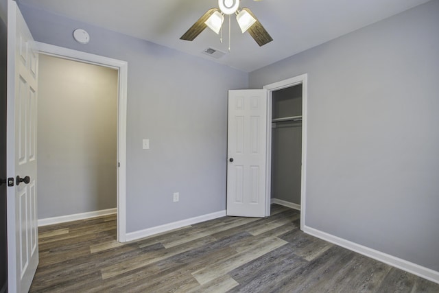 unfurnished bedroom with dark wood-type flooring, ceiling fan, and a closet