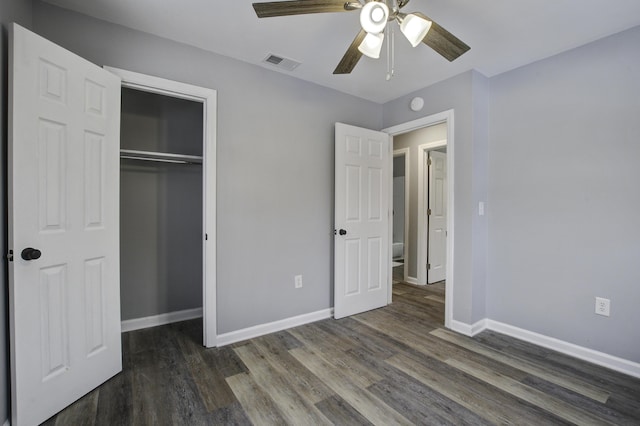 unfurnished bedroom with dark wood-type flooring, a closet, and ceiling fan