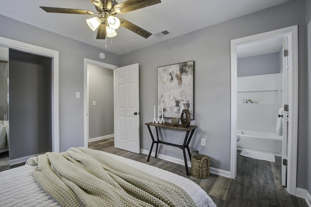 bedroom featuring ceiling fan, dark hardwood / wood-style flooring, and ensuite bath