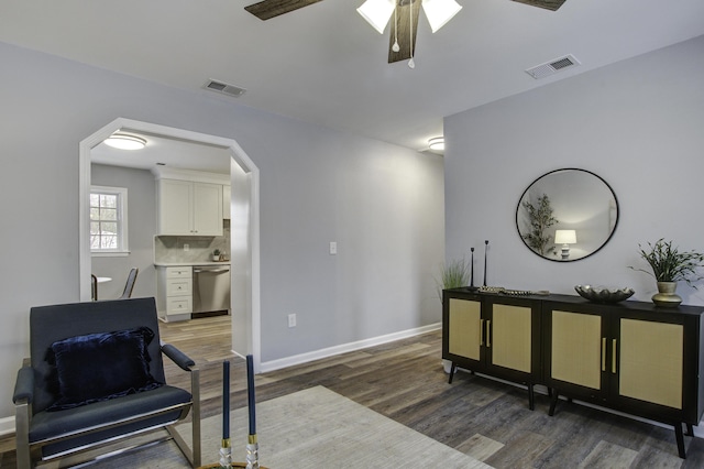 sitting room featuring dark wood-type flooring and ceiling fan