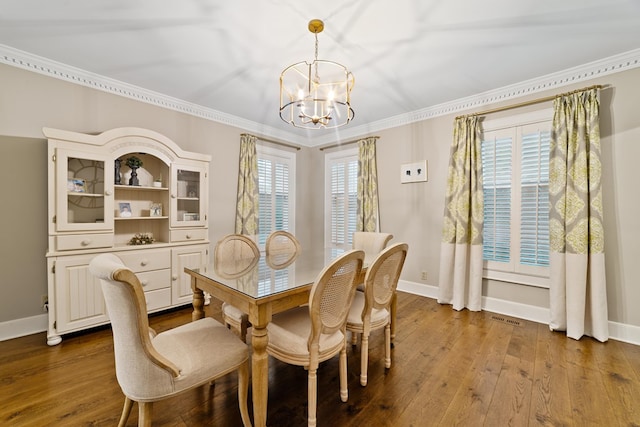 dining area featuring an inviting chandelier, hardwood / wood-style flooring, ornamental molding, and a wealth of natural light