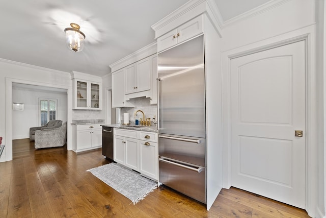 kitchen with white cabinets, dark wood-type flooring, sink, appliances with stainless steel finishes, and backsplash