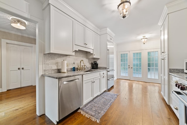 kitchen featuring appliances with stainless steel finishes, light wood-type flooring, and white cabinets