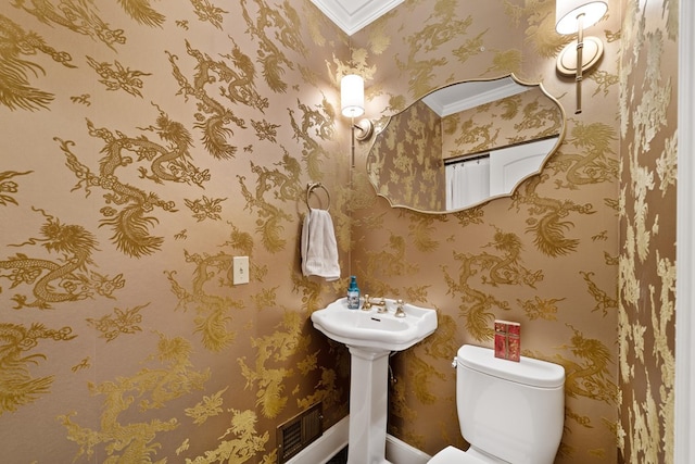 bathroom featuring crown molding, toilet, and sink