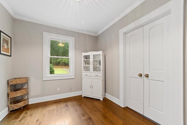 unfurnished bedroom featuring wood-type flooring, a closet, and crown molding