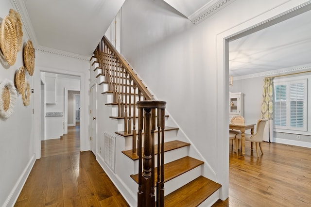 staircase featuring crown molding and wood-type flooring