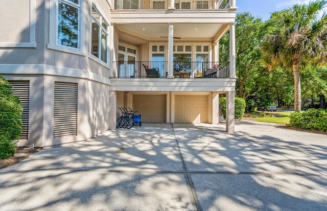 12 Port Tack, Hilton Head Island, SC 29928 - back of house with a balcony, an attached garage, driveway, and stucco siding