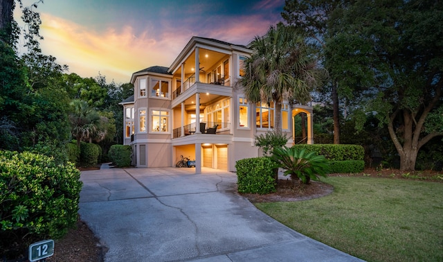 12 Port Tack, Hilton Head Island, SC 29928 - view of front of house with a balcony, stucco siding, an attached garage, driveway, and a front lawn