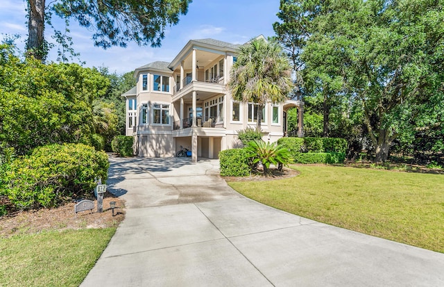 12 Port Tack, Hilton Head Island, SC 29928 - view of front facade featuring a balcony, concrete driveway, stucco siding, a front lawn, and a garage