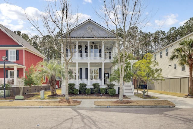 view of front of home featuring a ceiling fan, a balcony, stairs, fence, and a porch