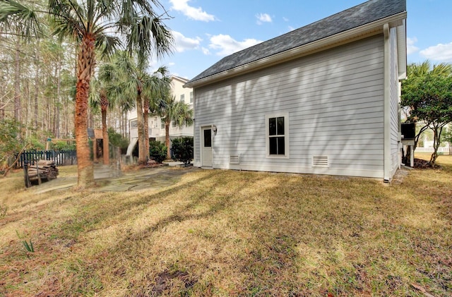 view of side of home with a yard and fence