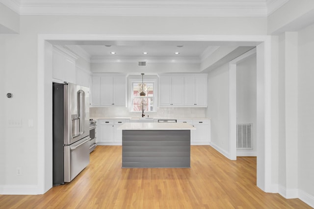 kitchen featuring stainless steel appliances, a kitchen island, visible vents, white cabinets, and light countertops