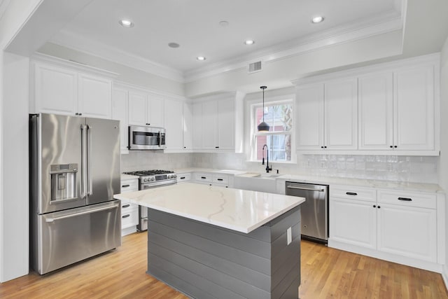 kitchen with visible vents, white cabinets, a kitchen island, appliances with stainless steel finishes, and hanging light fixtures