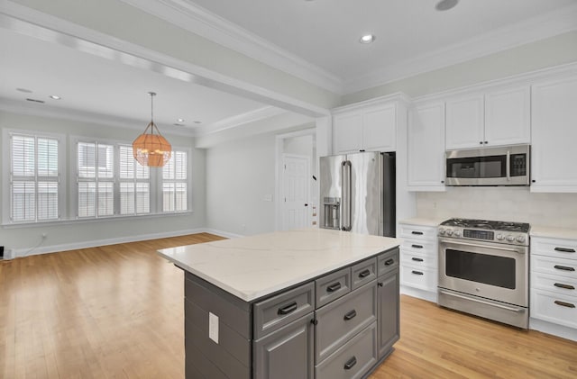 kitchen featuring a center island, stainless steel appliances, gray cabinets, white cabinetry, and light stone countertops