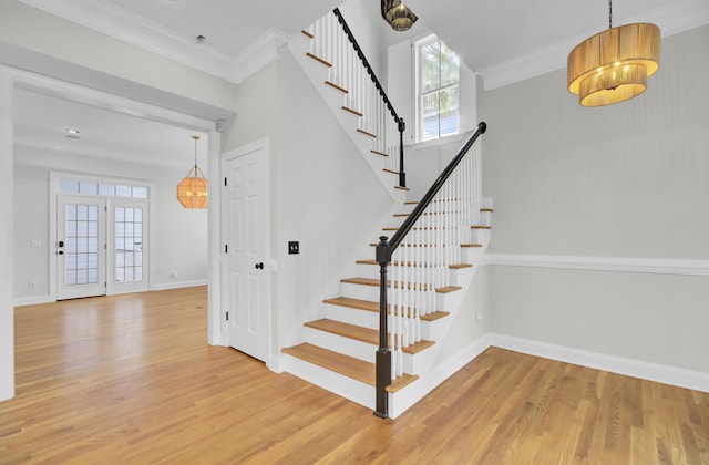 staircase featuring baseboards, crown molding, and wood finished floors