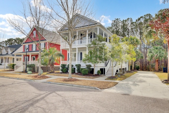 view of front of house featuring covered porch, driveway, and stairway