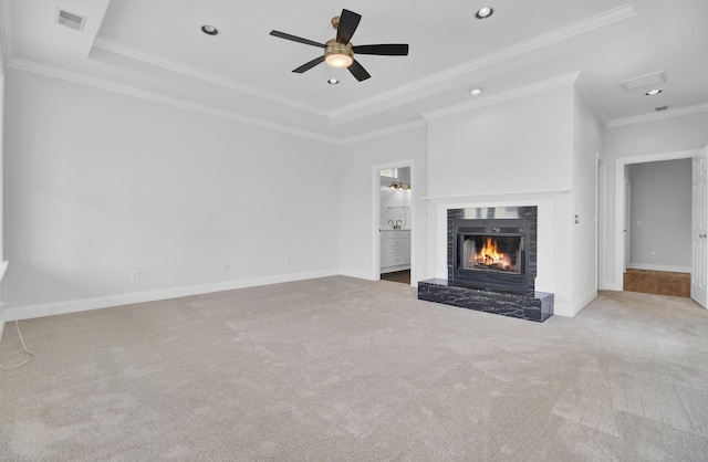 unfurnished living room featuring light carpet, visible vents, a raised ceiling, baseboards, and a lit fireplace