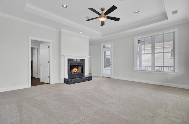 unfurnished living room with a fireplace, a tray ceiling, and ornamental molding