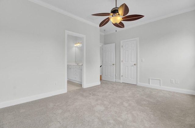 unfurnished bedroom featuring light carpet, crown molding, baseboards, and ensuite bathroom