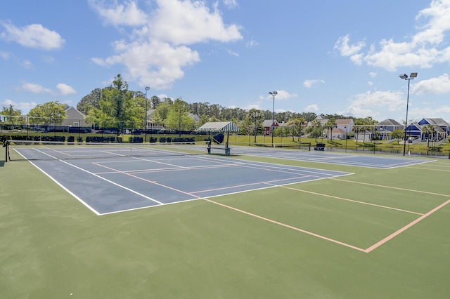 view of tennis court featuring fence