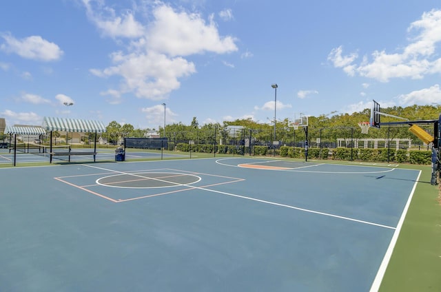 view of sport court featuring a tennis court, community basketball court, and fence