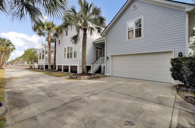 view of side of property featuring a garage and concrete driveway