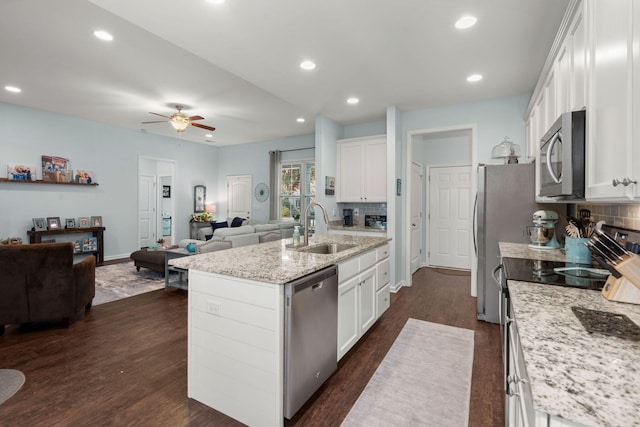 kitchen featuring white cabinetry, sink, dark hardwood / wood-style flooring, a kitchen island with sink, and appliances with stainless steel finishes