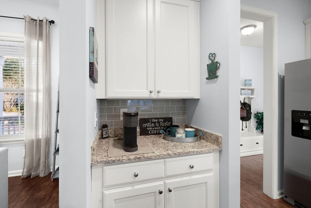 kitchen with dark wood-type flooring, white cabinets, light stone countertops, tasteful backsplash, and stainless steel fridge with ice dispenser