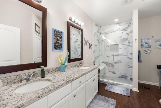 bathroom with wood-type flooring, vanity, and a shower with shower door