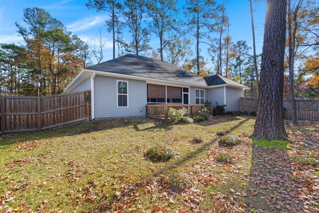 rear view of property featuring a yard and a wooden deck