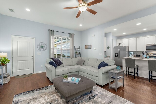 living room featuring dark hardwood / wood-style flooring and ceiling fan