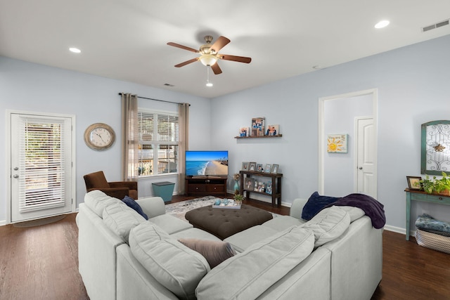 living room featuring ceiling fan and dark wood-type flooring