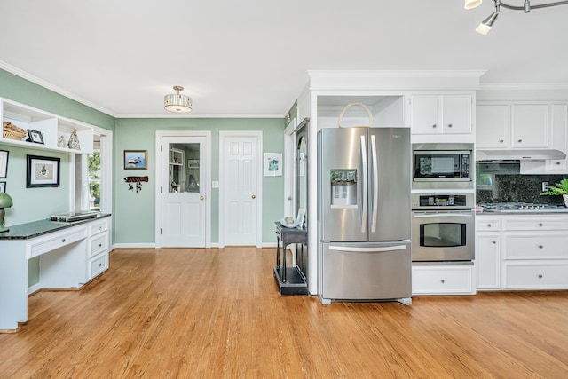 kitchen featuring light hardwood / wood-style flooring, appliances with stainless steel finishes, ornamental molding, white cabinets, and decorative backsplash