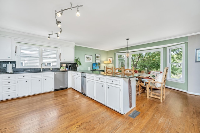 kitchen featuring ornamental molding, stainless steel dishwasher, white cabinets, and kitchen peninsula