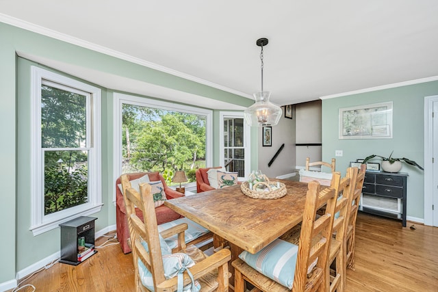 dining space featuring crown molding, a wealth of natural light, and light hardwood / wood-style floors