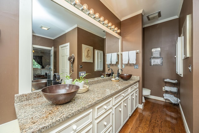 bathroom featuring hardwood / wood-style flooring, vanity, toilet, and crown molding