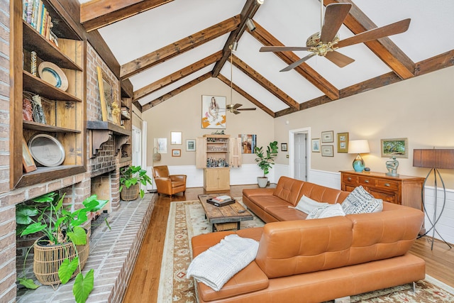 living room with beamed ceiling, high vaulted ceiling, hardwood / wood-style flooring, and a fireplace