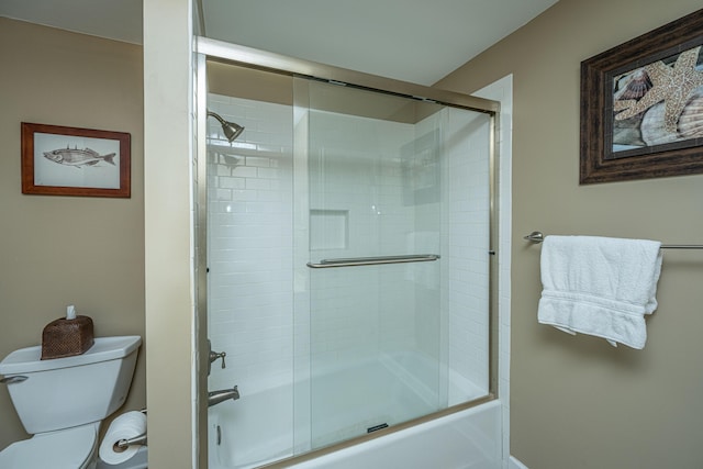 bathroom featuring enclosed tub / shower combo and toilet