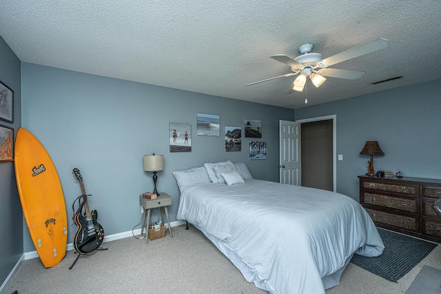 carpeted bedroom featuring a textured ceiling and ceiling fan