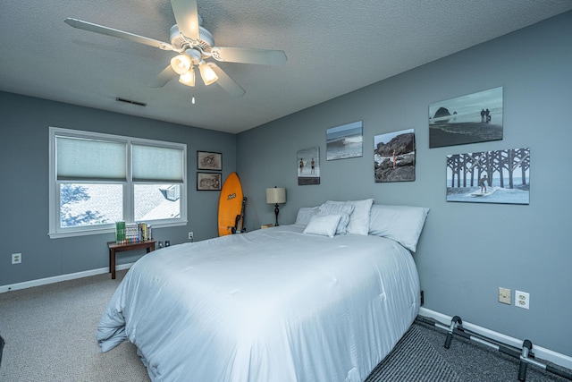 carpeted bedroom featuring ceiling fan and a textured ceiling