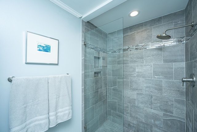 bathroom featuring ornamental molding and tiled shower