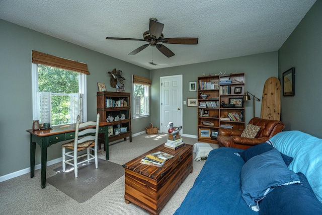 carpeted living room featuring ceiling fan and a textured ceiling