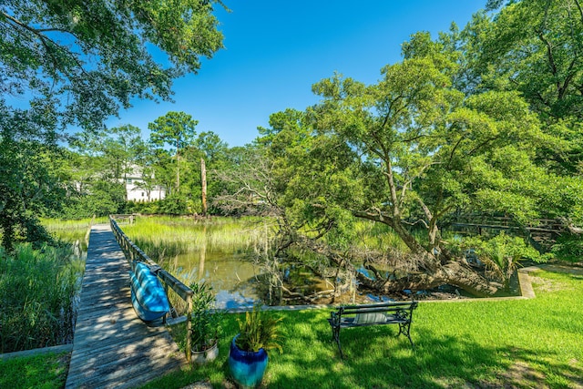 view of property's community featuring a lawn and a water view