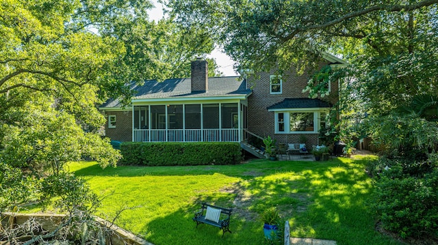 back of property featuring a sunroom and a yard